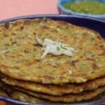 Image of Besan Jowar Thalipeeth and chutney on the side.